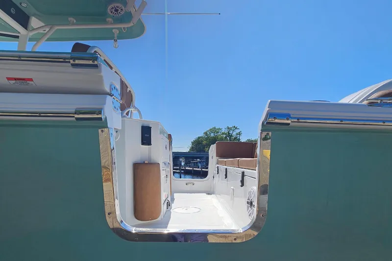 Slide: The Image of 2026 Sea Hunt Ultra 255 SE boat interior with seating, under clear blue sky. - 8