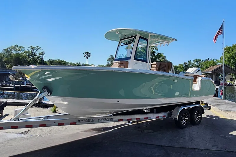 Slide: The Image of 2026 Sea Hunt Ultra 255 SE boat on trailer at dockside under clear blue sky. - 9