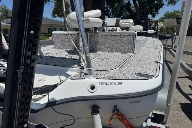 Slide: The Image of 2004 Ranger 191 Cayman boat with Evinrude motor, docked outdoors. - 5