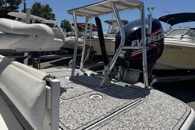 Slide: The Image of 2004 Ranger 191 Cayman boat with Evinrude motor, docked among other boats. - 9