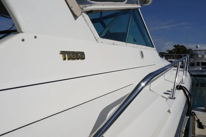 Slide: The Image of 1994 Tiara Yachts 4000 Express boat with sleek white exterior and chrome railing. - 10