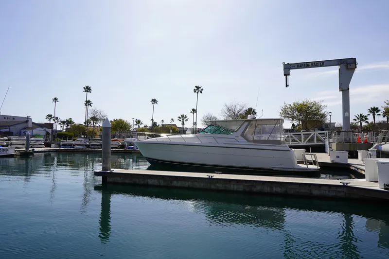 Slide: The Image of 1994 Tiara Yachts 4000 Express docked at marina with palm trees in background. - 13