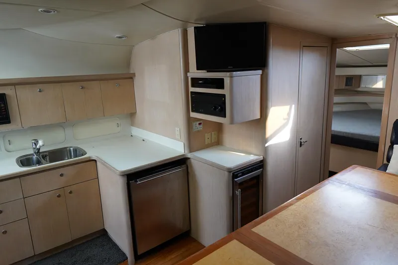 Slide: The Image of Interior of a 1994 Tiara Yachts 4000 Express, featuring a compact kitchen and cozy cabin space. - 22