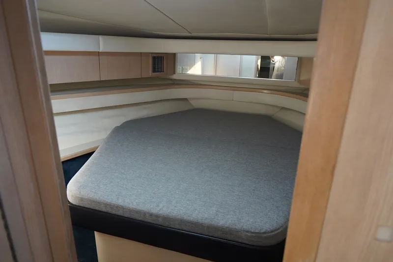 Slide: The Image of Interior cabin of 1994 Tiara Yachts 4000 Express, featuring a cozy bed and wooden accents. - 23
