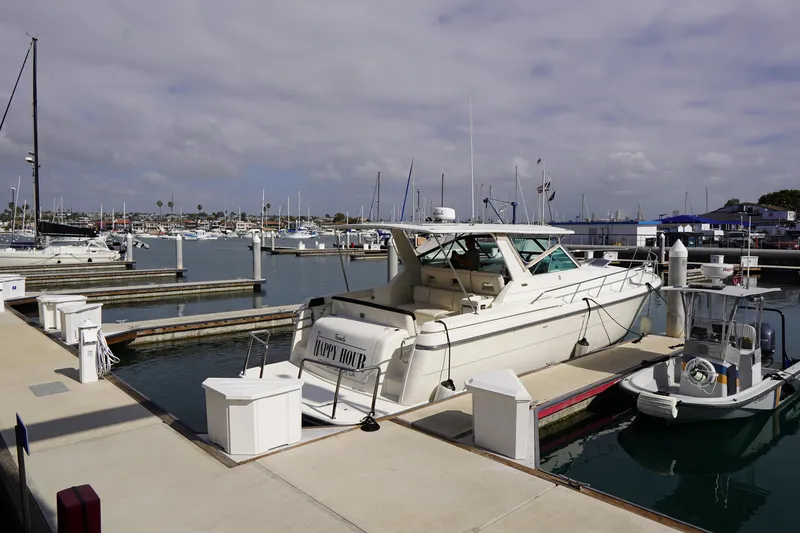 Slide: The Image of 1994 Tiara Yachts 4000 Express docked at a marina under a cloudy sky. - 35