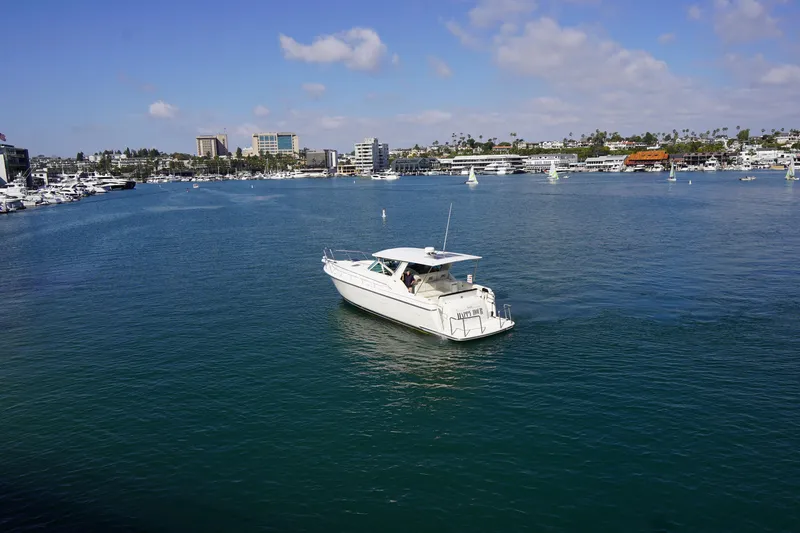 Slide: The Image of 1994 Tiara Yachts 4000 Express cruising in a scenic marina under a clear blue sky. - 5