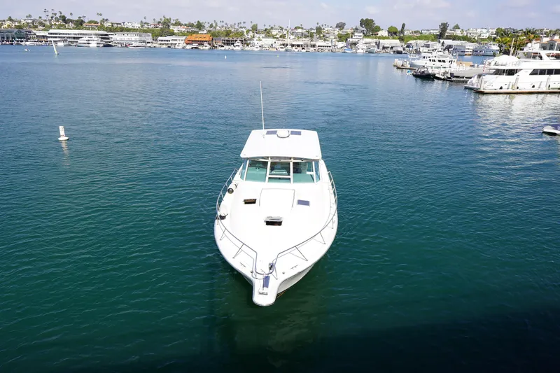 Slide: The Image of 1994 Tiara Yachts 4000 Express on calm water, marina in background. - 6