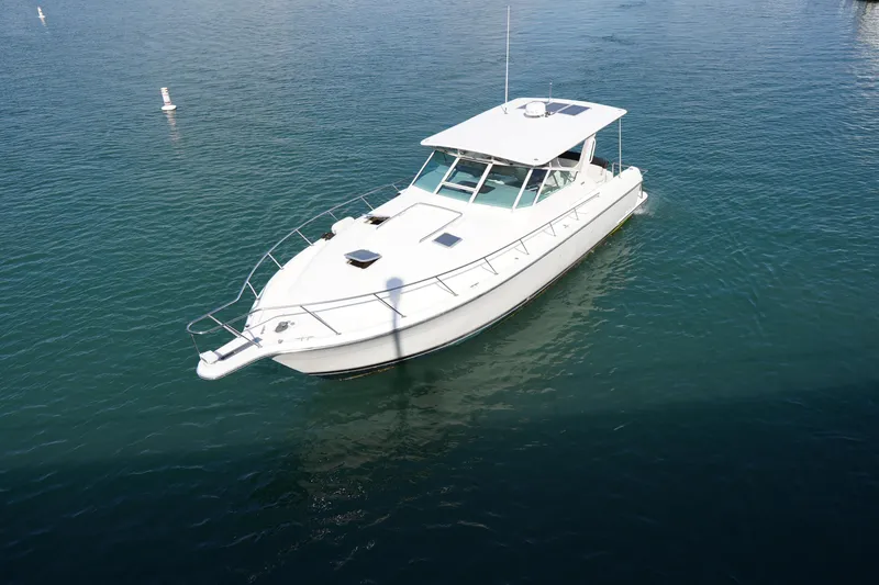 Slide: The Image of 1994 Tiara Yachts 4000 Express cruising on calm blue waters. - 7