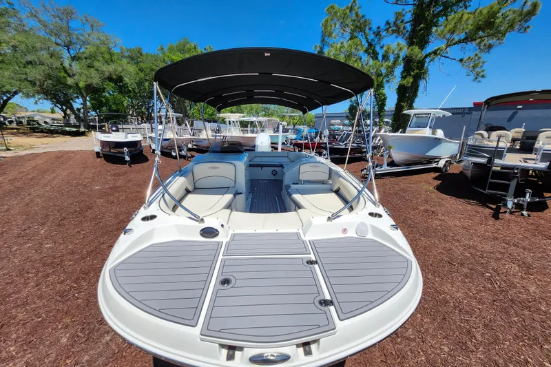 Slide: The Image of 2024 Stingray 212 SC boat with canopy, displayed outdoors on a sunny day. - 13