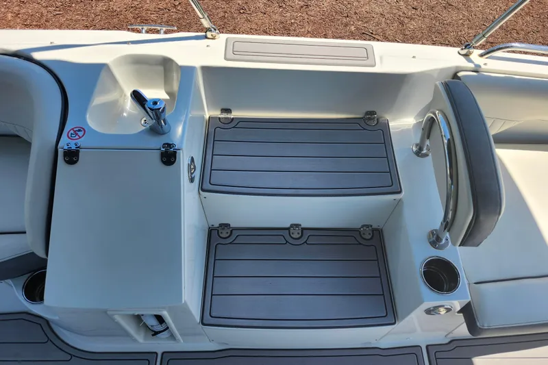 Slide: The Image of 2024 Stingray 212 SC boat interior with seating, storage compartments, and cup holders. - 20