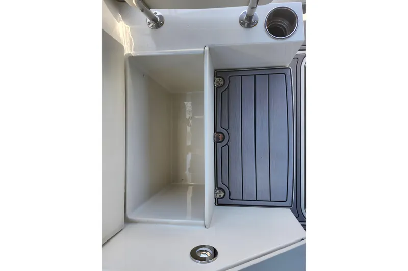Slide: The Image of 2024 Stingray 212 SC boat interior with storage compartment and cup holder. - 21