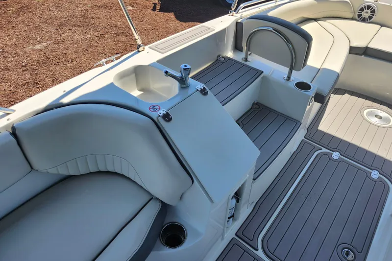 Slide: The Image of 2024 Stingray 212 SC boat interior with seating, sink, and cup holders. - 22