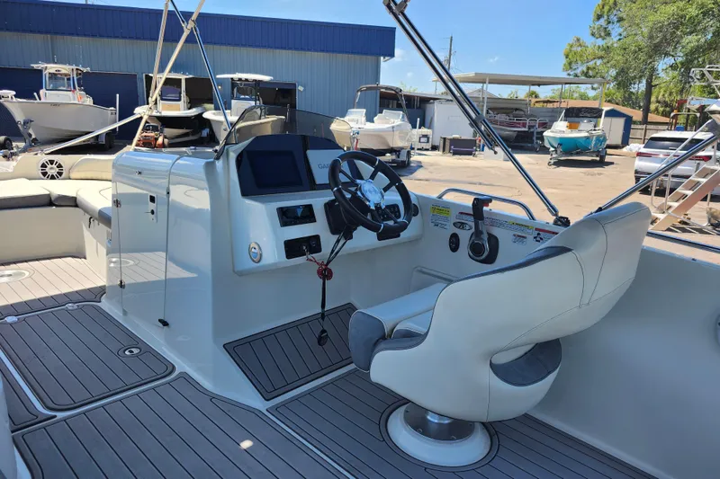 Slide: The Image of 2024 Stingray 212 SC boat interior with steering wheel and control panel. - 23