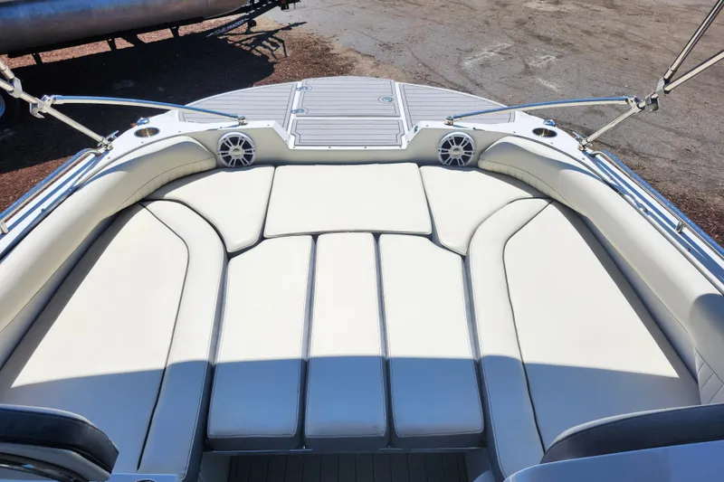 Slide: The Image of 2024 Stingray 212 SC boat interior with white cushioned seating and speakers. - 29