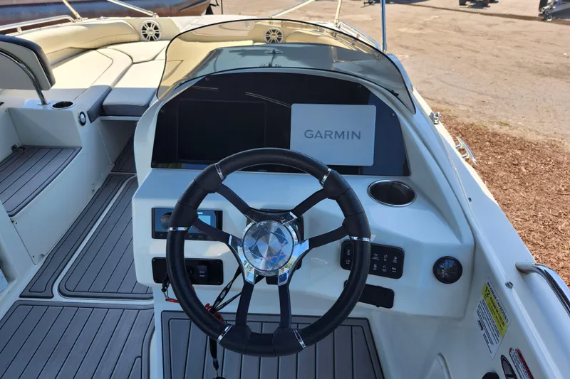 Slide: The Image of 2024 Stingray 212 SC boat dashboard with Garmin navigation system and steering wheel. - 32