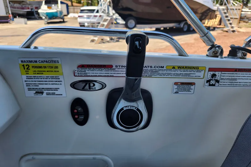 Slide: The Image of 2024 Stingray 212 SC boat control panel with capacity and safety warnings. - 33
