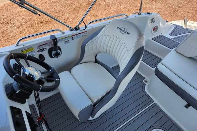 Slide: The Image of 2024 Stingray 212 SC boat interior with steering wheel and captain's chair. - 34