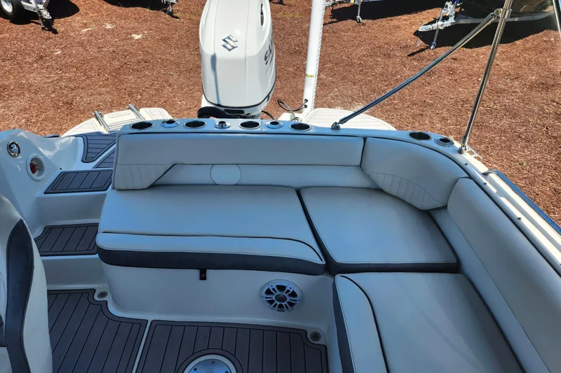 Slide: The Image of 2024 Stingray 212 SC boat interior with cushioned seating and Suzuki outboard motor. - 36
