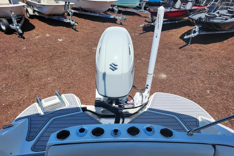 Slide: The Image of 2024 Stingray 212 SC boat with Suzuki outboard motor, docked on a trailer. - 37
