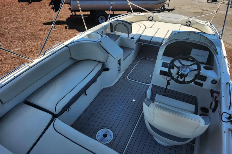 Slide: The Image of 2024 Stingray 212 SC boat interior with seating, steering wheel, and Garmin navigation system. - 43