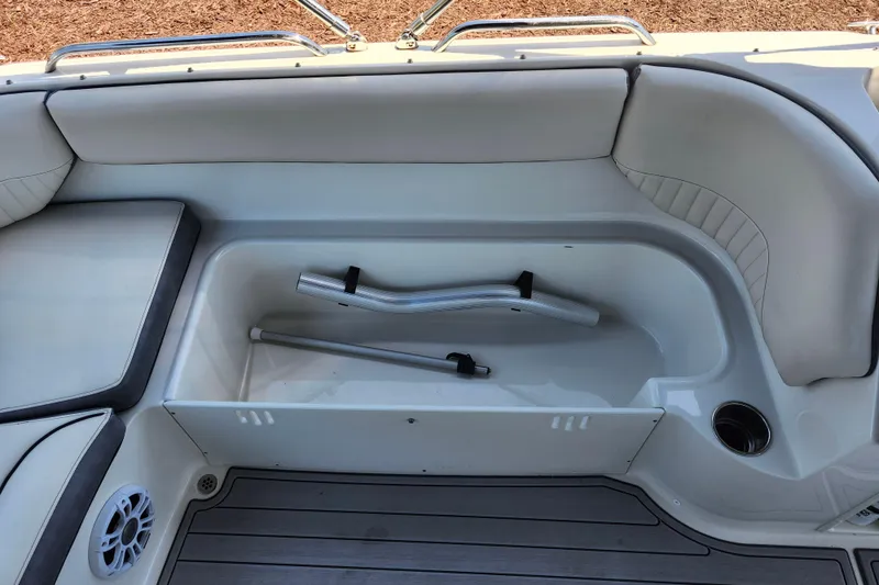 Slide: The Image of 2024 Stingray 212 SC boat interior storage compartment with seating and cup holder. - 44
