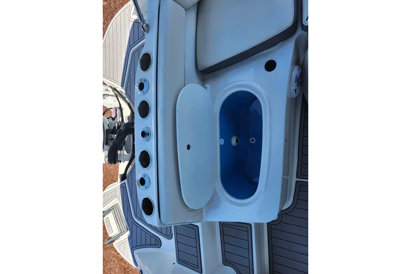 Slide: The Image of 2024 Stingray 212 SC boat interior with cup holders and storage compartment. - 45
