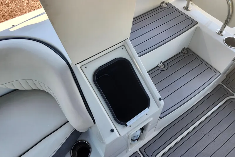 Slide: The Image of 2024 Stingray 212 SC boat interior with open storage compartment and cushioned seating. - 46