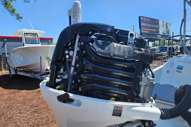 Slide: The Image of 2024 Stingray 212 SC boat with powerful outboard motor, displayed outdoors. - 48