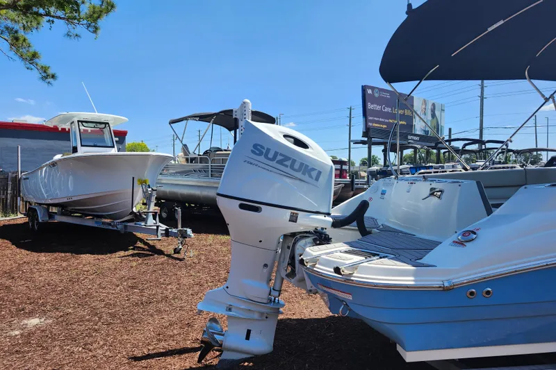 Slide: The Image of 2024 Stingray 212 SC boat with Suzuki outboard motor in a dealership lot. - 8