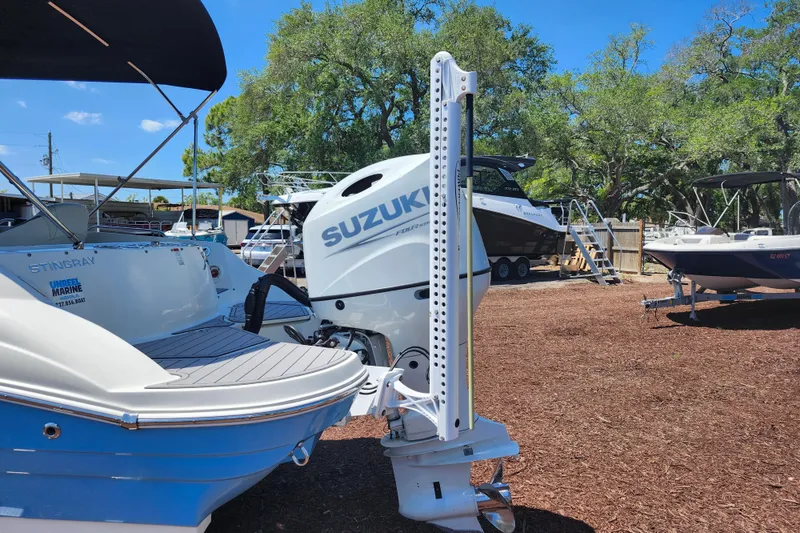 Slide: The Image of 2024 Stingray 212 SC boat with Suzuki outboard motor in a sunny outdoor setting. - 9