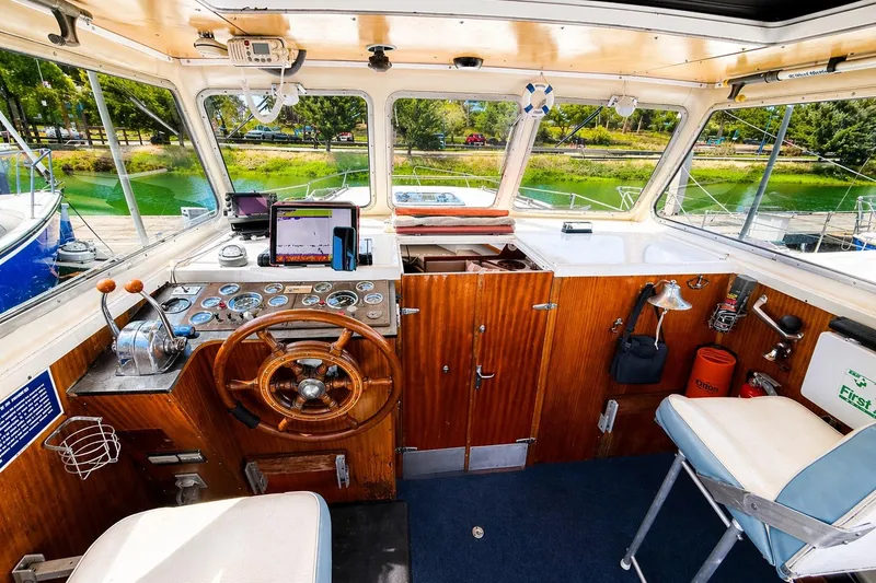 Slide: The Image of 1975 Apollo 32 Deluxe TT boat interior with wooden helm, steering wheel, and navigation equipment. - 5