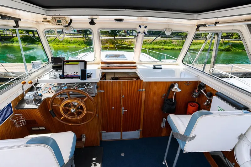 Slide: The Image of Interior of a 1975 Apollo 32 Deluxe TT boat with cushioned seating and wooden accents. - 6