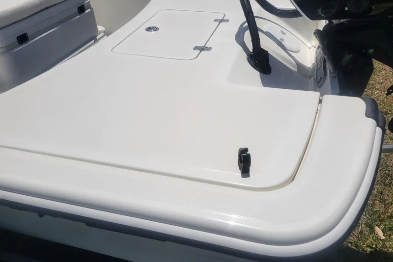 Slide: The Image of 2024 Mako Pro Skiff 17 CC boat deck, featuring storage compartment and seating area. - 6