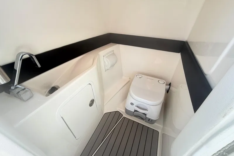 Slide: The Image of 2023 Sea Ray SLX 260 boat bathroom with compact toilet and modern sink design. - 16