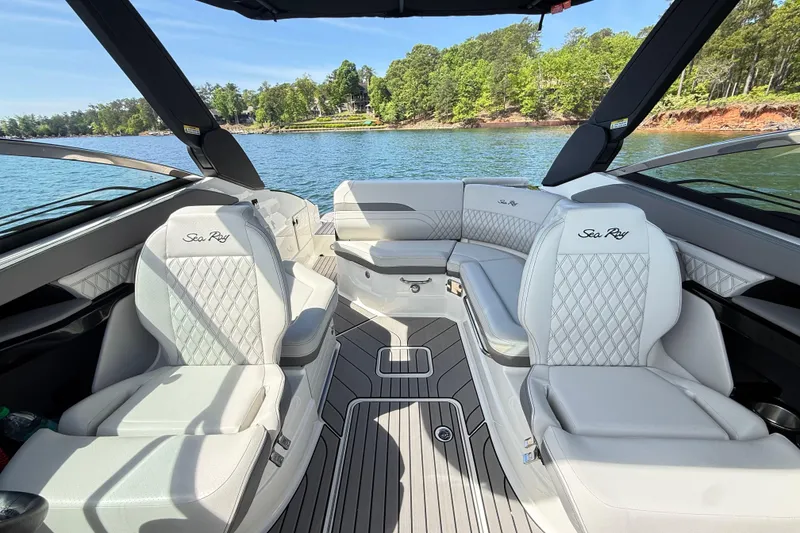 Slide: The Image of 2023 Sea Ray SLX 260 boat interior with luxurious seating on a scenic lake. - 21