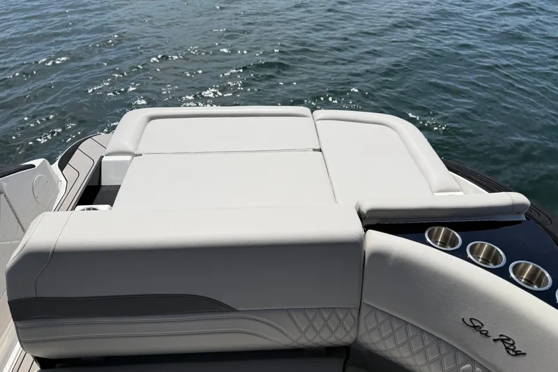 Slide: The Image of 2023 Sea Ray SLX 260 boat with luxurious seating and cup holders on the water. - 24
