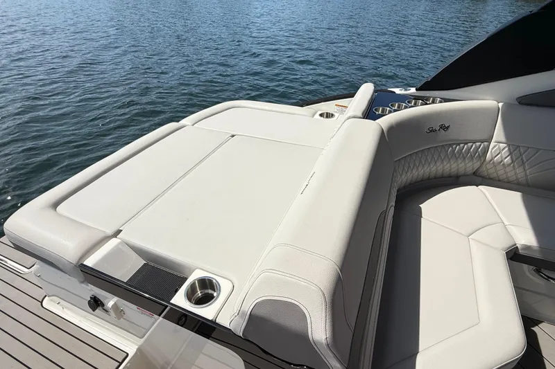 Slide: The Image of 2023 Sea Ray SLX 260 boat with luxurious seating and cup holders on a sunny day. - 25