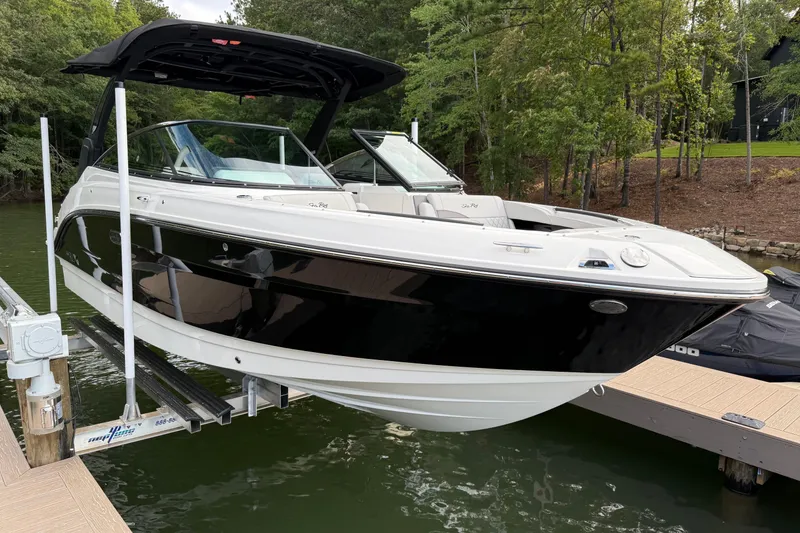 Slide: The Image of 2023 Sea Ray SLX 260 boat docked on a lift, surrounded by lush greenery. - 3