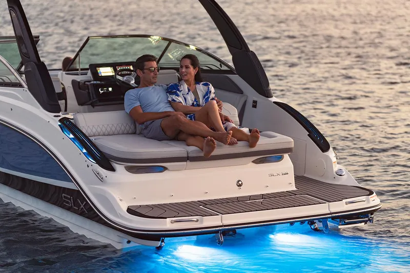 Slide: The Image of Manufacturer Provided Image: Couple relaxing on a 2023 Sea Ray SLX 260 boat with blue underwater lights. - 30