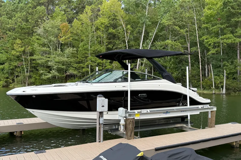 Slide: The Image of 2023 Sea Ray SLX 260 boat docked on a lift, surrounded by lush greenery. - 4