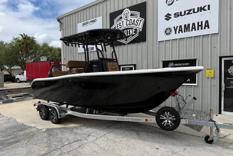The Image of 2026 Sea Pro 225FLX Sandbar boat on trailer outside marine service center. - 1