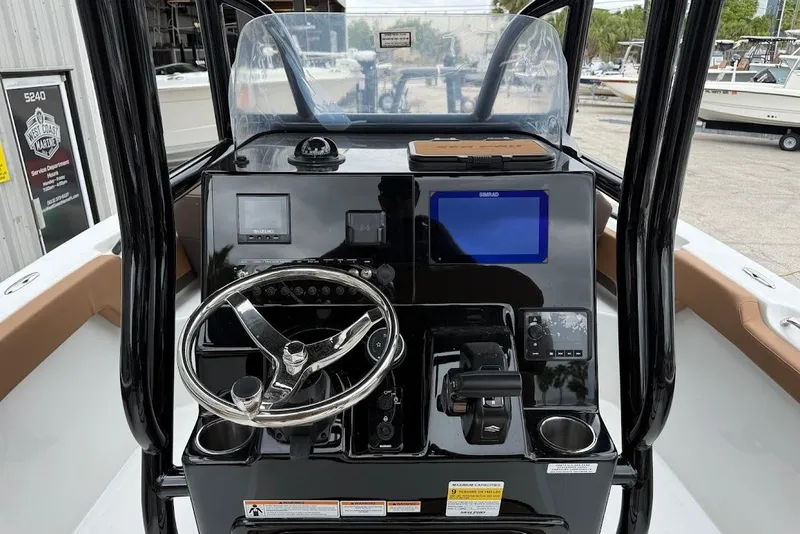 Slide: The Image of 2026 Sea Pro 225FLX Sandbar boat dashboard with steering wheel and navigation controls. - 9