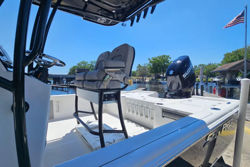 Slide: The Image of 2022 Sea Pro 228 Bay boat docked, featuring seating and Suzuki outboard motor. - 10