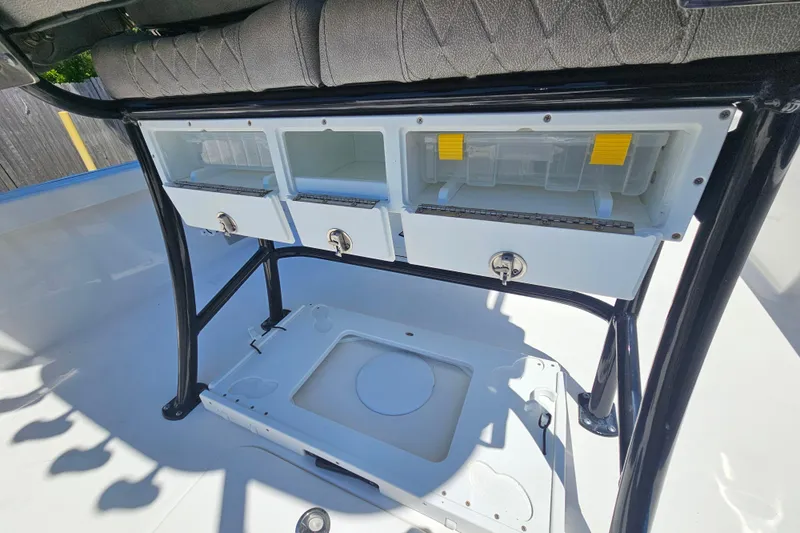 Slide: The Image of 2022 Sea Pro 228 Bay boat storage compartments with tackle boxes and seating. - 11