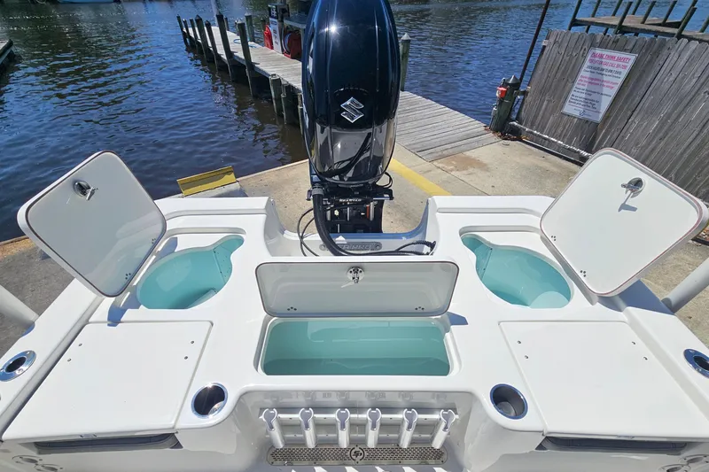 Slide: The Image of 2022 Sea Pro 228 Bay boat with open storage compartments and Suzuki outboard motor. - 13