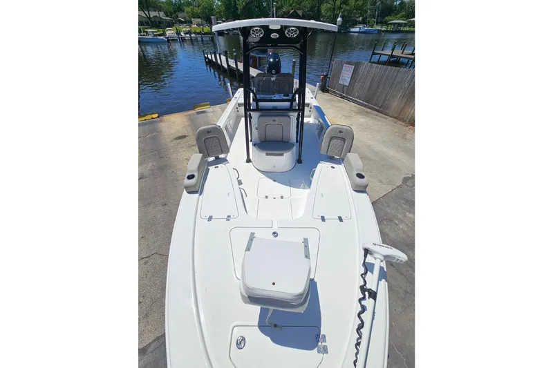 Slide: The Image of 2022 Sea Pro 228 Bay boat at dock, featuring spacious deck and modern design. - 15