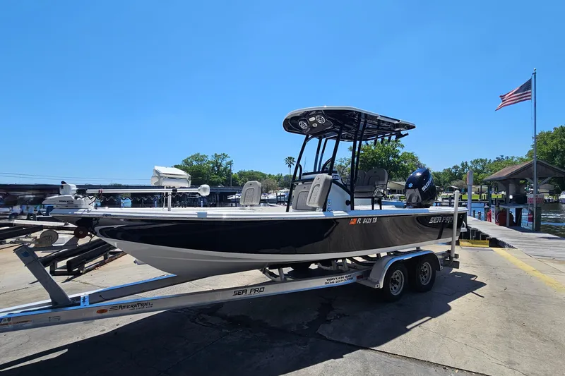 Slide: The Image of 2022 Sea Pro 228 Bay boat on trailer at dockside under clear blue sky. - 8