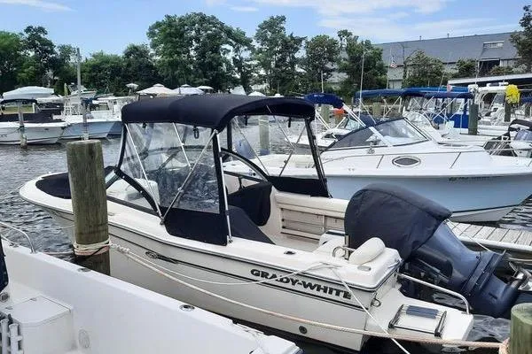 Slide: The Image of 2016 Grady-White Freedom 205 boat docked in a marina with other vessels. - 10