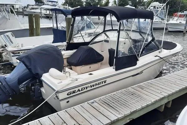 Slide: The Image of 2016 Grady-White Freedom 205 boat docked at marina with canopy and outboard motor. - 11