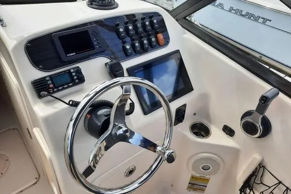 Slide: The Image of Control panel of a 2016 Grady-White Freedom 205 boat with steering wheel and electronics. - 16
